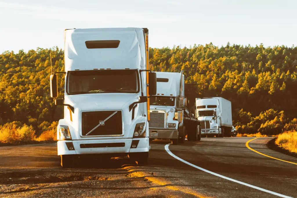 Various types of trucks travelling on the highway.